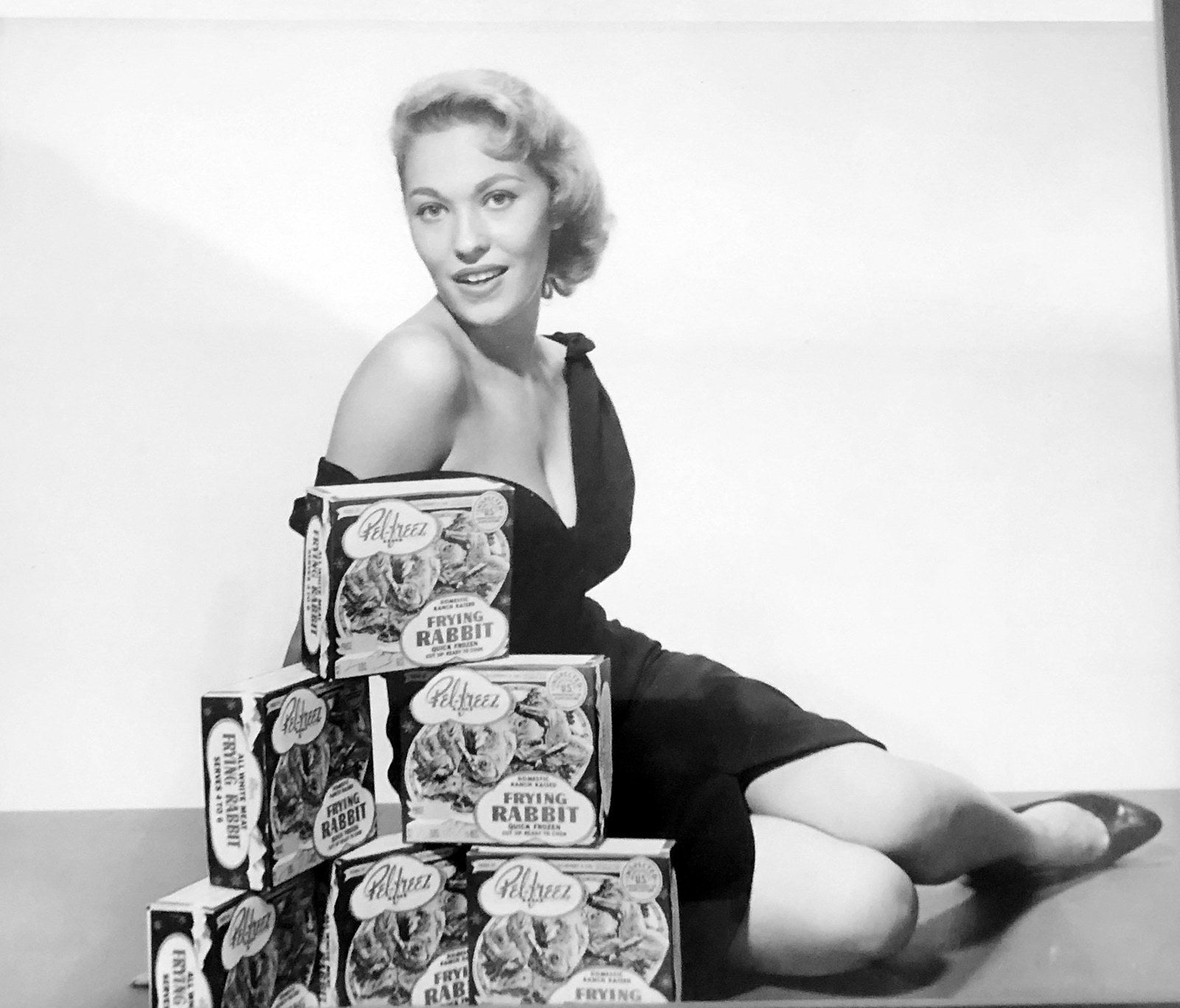 Lola Mason, “Miss Pel-Freez Frozen Rabbit Meat,” poses with a stack of Pel-Freez Frying Rabbit